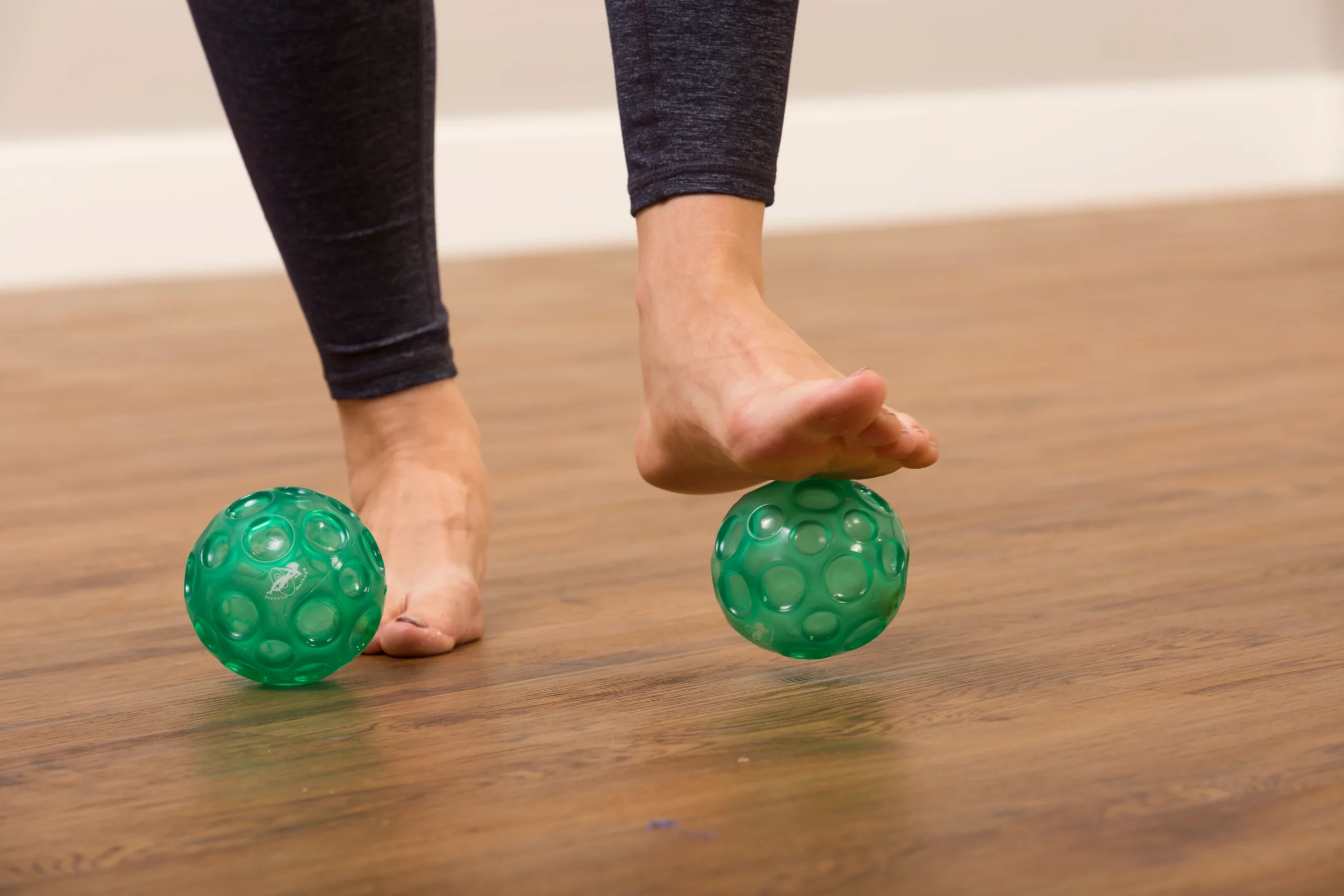 ejercicio con pelotas estriadas de color verde bajo de las plantas de los pies