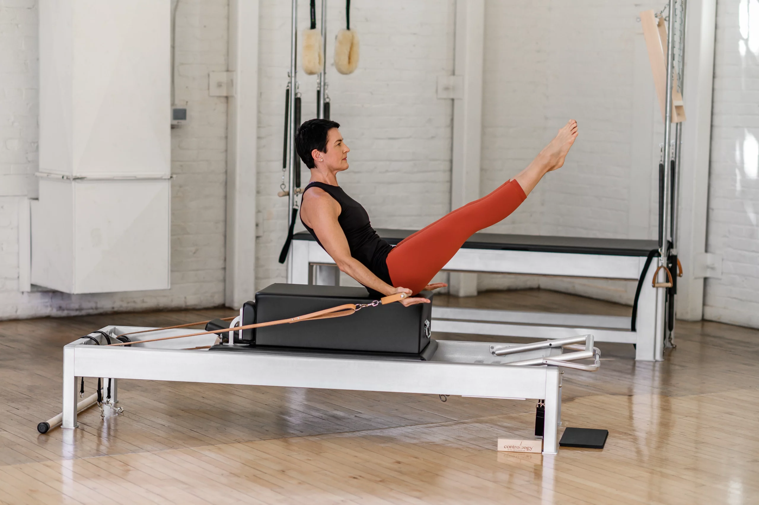 una mujer haciendo una pose del curso de pilates reformer 3 de balanced body